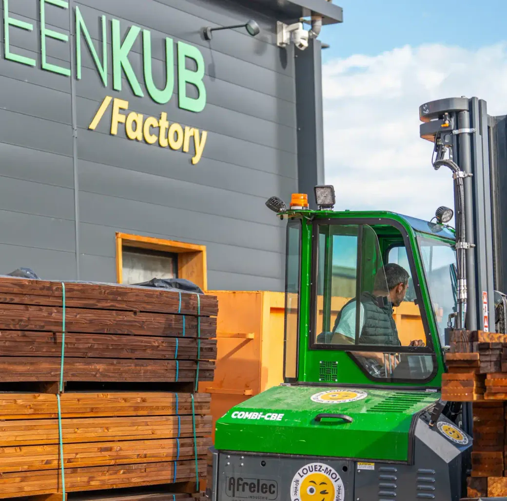 Un opérateur Greenkub déplace des lots de bois devant la Greenkub Factory, notre atelier de fabrication à Castries (34).
