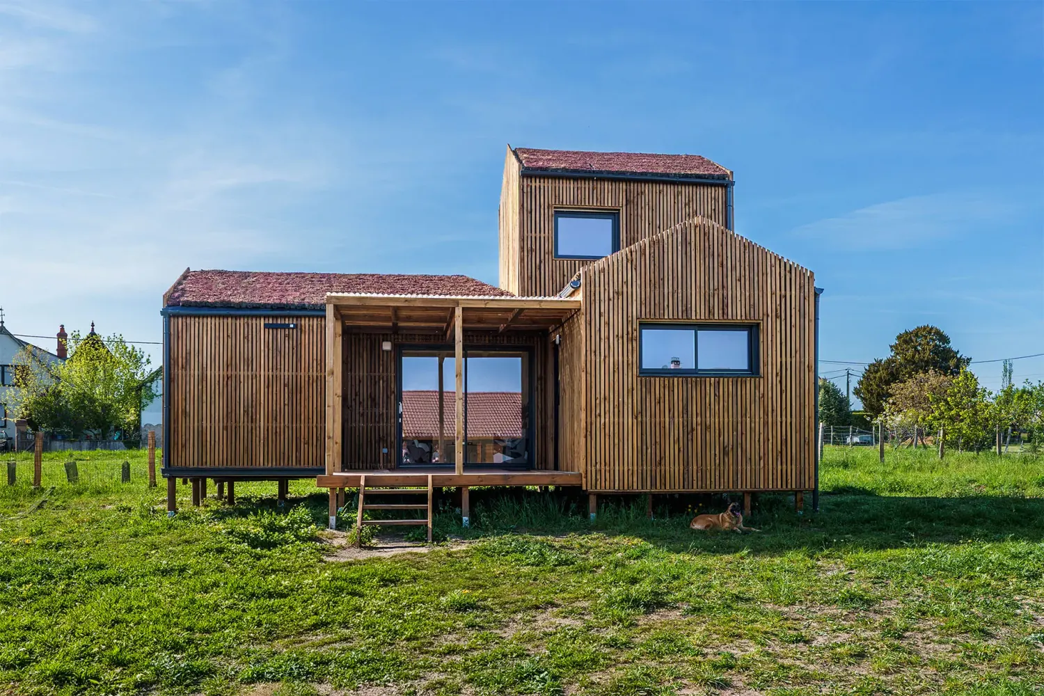 Extérieur maison à ossature bois, fabriqué en atelier 50m² · trois volumes imbriqués, toiture sédum, terrasse couverte pergola