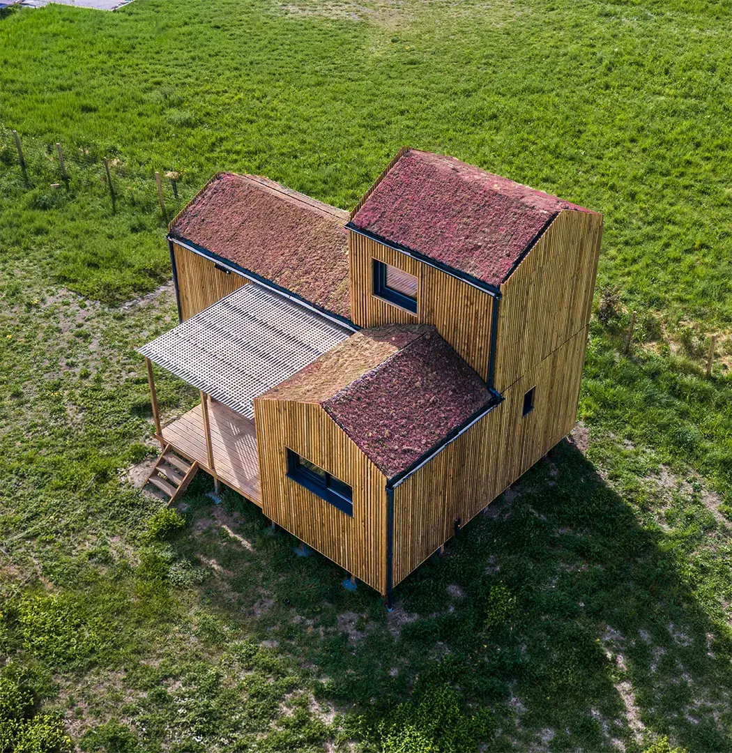 GK50 Greenkub depuis les airs · implantation terrain naturel, composition volumétrique bois et toits verts, Allier
