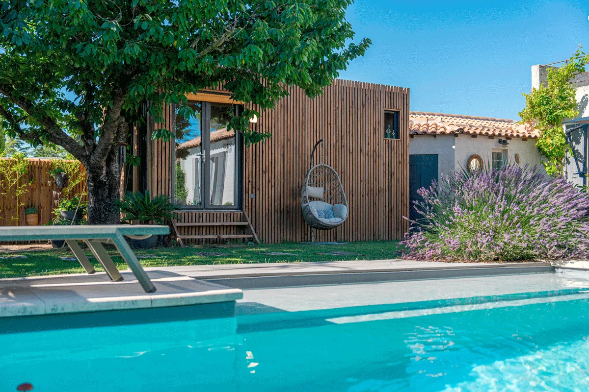Une petite construction en bois au bord d’une piscine