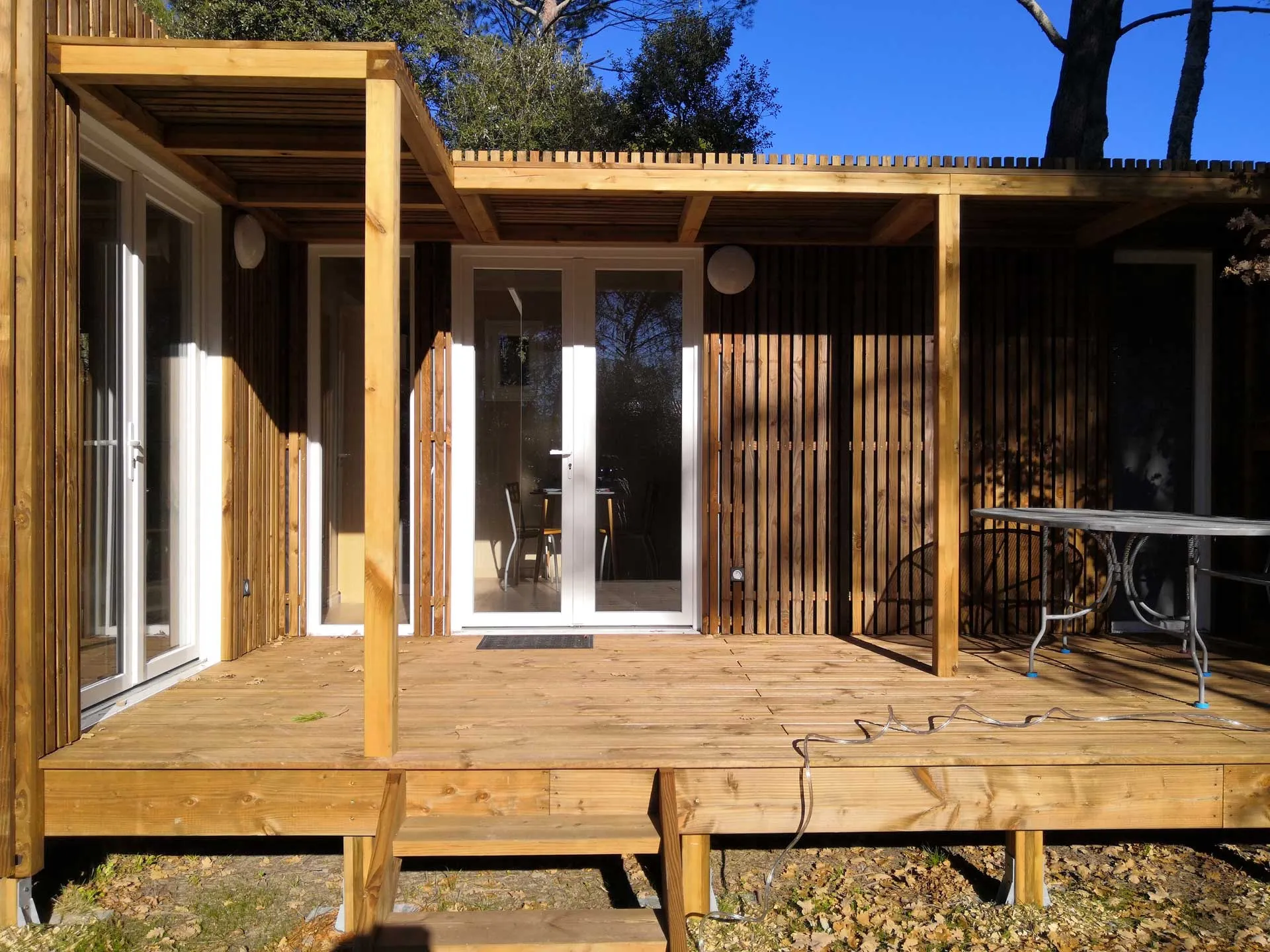 Studio sur mesure avec une extension de terrasse et des menuiseries blanches