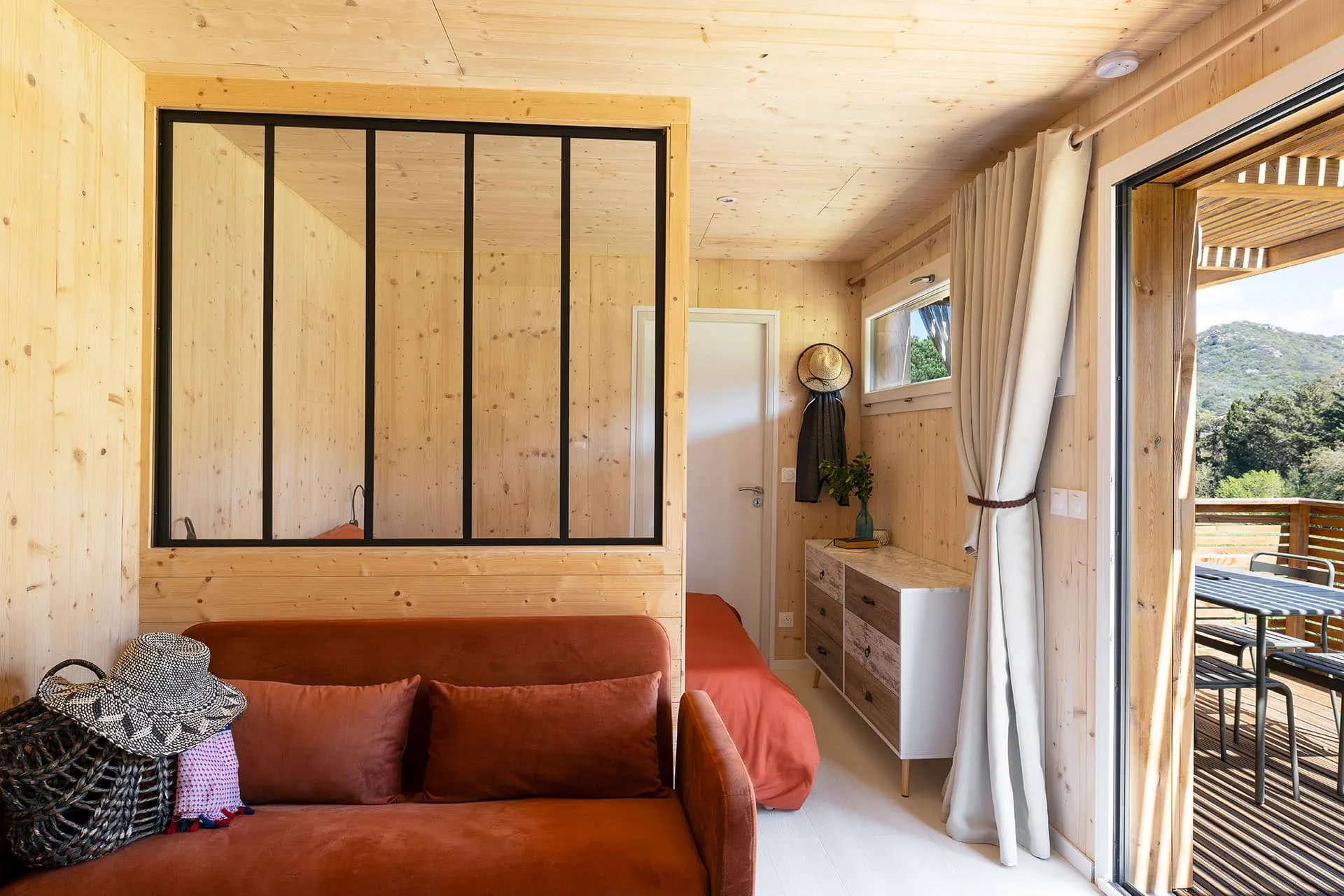 Intérieur d’un Greenkub GK20 : coin cuisine équipé avec évier, micro-ondes et plaques, ouvert sur la chambre