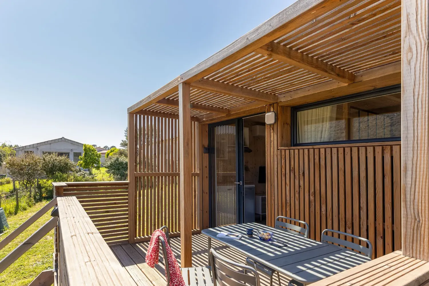 Détail de la terrasse d’un GK20 Greenkub : lames de bois horizontales, montants verticaux et garde-corps ajouré