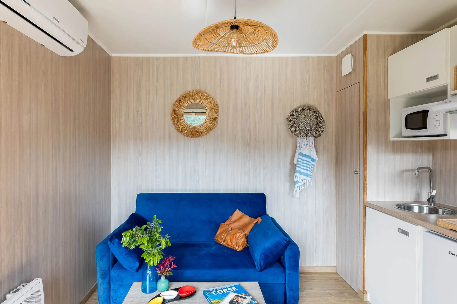 Kitchenette compacte d’un GK20 Greenkub : plan de travail bois, réfrigérateur intégré et rangements muraux