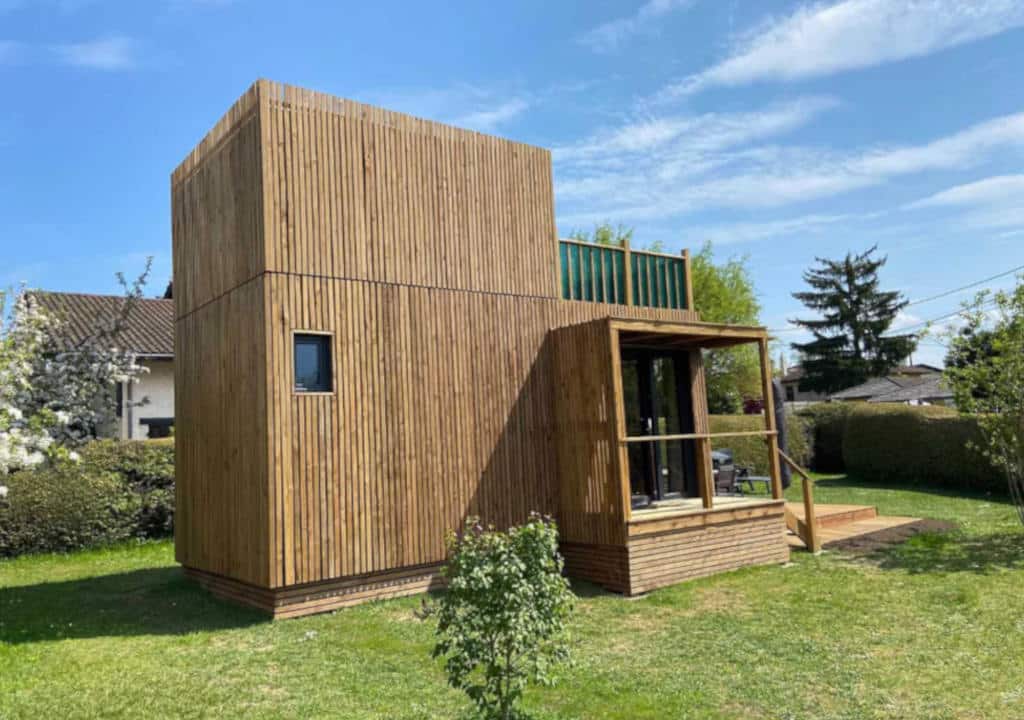 Dépendance jardin habitable en bois massif posée dans un jardin résidentiel français